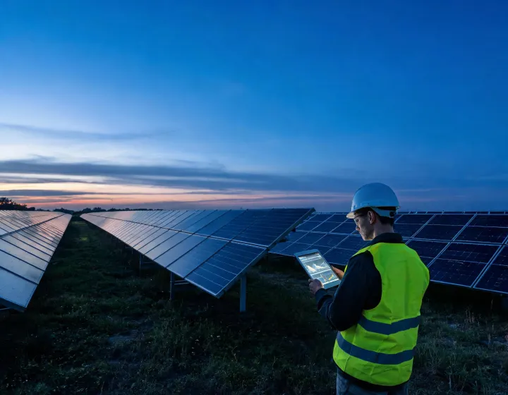 PV engineer reviewing module technology data beside a solar test field